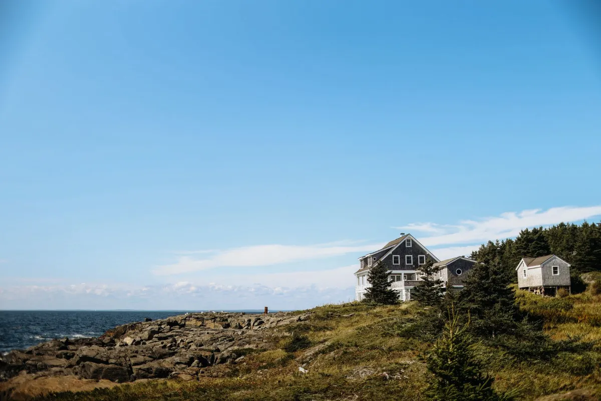 Shingled houses on a rocky coastal bluff above the ocean